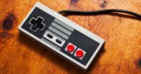 A retro video game controller rests on top of a wooden table