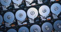 Overhead view of multiple open hard disk drives showing platters and actuator arms
