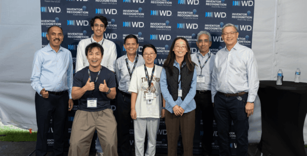 Seven WD inventor honorees and leaders posing together at WD Elevate event in front of WD Inventor Recognition branded backdrop.