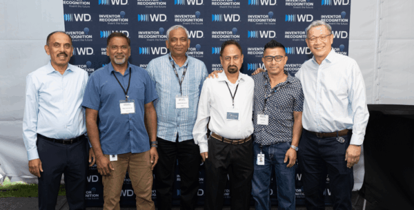 Six WD inventor honorees posing together at WD Elevate event in front of WD Inventor Recognition branded backdrop.